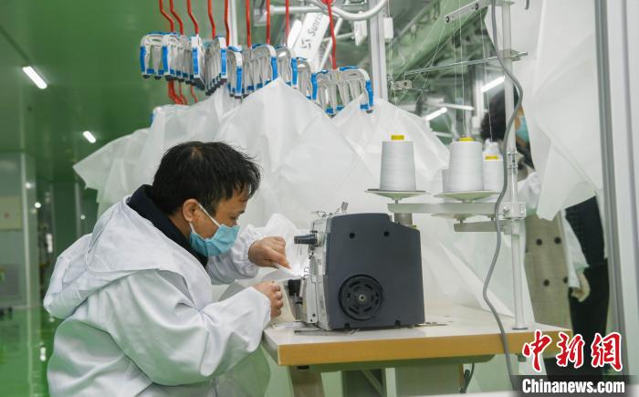 工人生產(chǎn)防護(hù)服，保障抗疫物資供應(yīng)。廣安市委宣傳部供圖