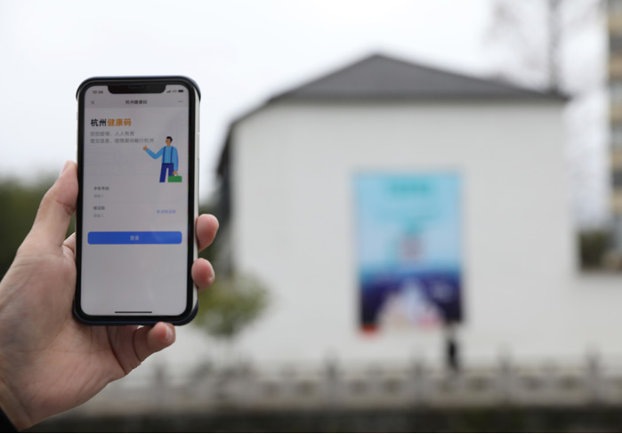在浙江省杭州市臨安區(qū)天目山鎮(zhèn)，一名居民在“杭州健康碼”海報(bào)上掃碼申領(lǐng)個(gè)人二維碼。新華社發(fā)