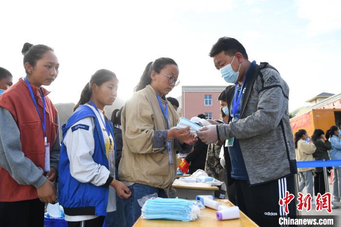 7月7日，考生在拉薩三高考點外領(lǐng)取口罩。　何蓬磊 攝