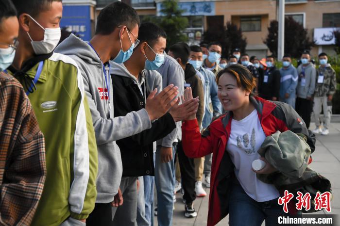 7月7日，拉薩三高考點外，領(lǐng)隊老師與考生擊掌鼓勁加油?！『闻罾?攝