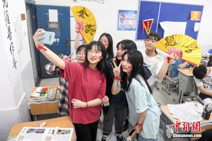 資料圖：6月6日，2021年高考前夕，湖南長(zhǎng)沙同升湖實(shí)驗(yàn)學(xué)校高三年級(jí)，考生們?cè)诮淌覂?nèi)合影。 楊華峰 攝