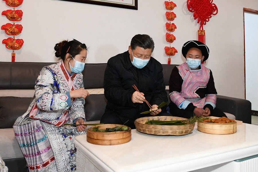 2021年2月3日下午，習(xí)近平在貴州畢節(jié)市黔西縣新仁苗族鄉(xiāng)化屋村苗族村民趙玉學(xué)家，同一家人邊聊家常邊制作當(dāng)?shù)貍鹘y(tǒng)節(jié)日食品黃粑。新華社記者 李學(xué)仁 攝